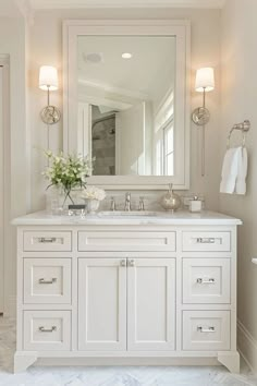 a white bathroom with two sinks and a large mirror