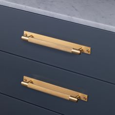 two drawers with brass handles and marble counter tops in a kitchen or living room area