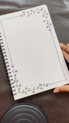 a person holding a notebook with flowers on it