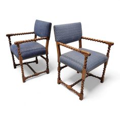 a pair of chairs with blue upholstered fabric and wooden frame, on white background