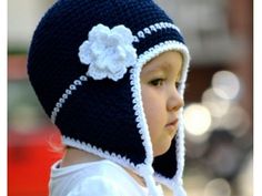 a young child wearing a knitted hat with flowers