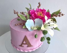 a pink cake with flowers and leaves on top