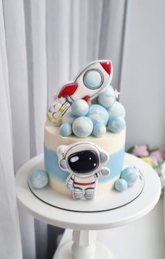 a cake decorated with an astronaut's rocket ship on top