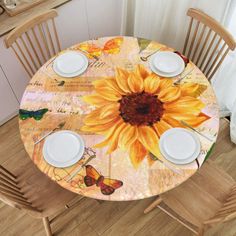 a sunflower on a table with white plates and placemats in front of it