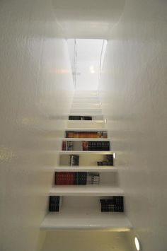 there are many books on the shelves in this room that is lit by light coming from the ceiling