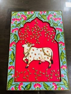 an intricately decorated card with a cow on it's side and flowers in the background