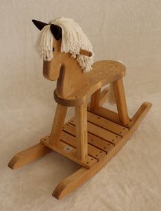 a wooden rocking horse with long hair on it's head