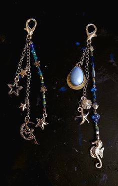 two different types of jewelry on a black surface with blue beads and charms hanging from them