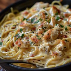 a plate of pasta with shrimp and parmesan cheese on top is ready to be eaten