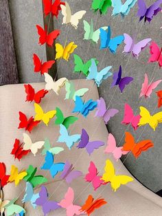 colorful paper butterflies are attached to the back of a chair