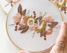 someone is stitching the word love with flowers