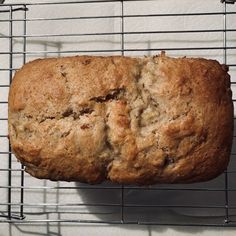 a loaf of bread sitting on top of a metal rack next to a white wall