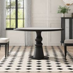 a black and white dining room with an oval table, two chairs and a clock on the wall