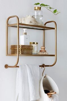 a bathroom shelf with towels, soaps and other items hanging from it's hooks