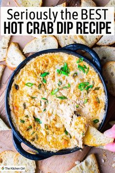 A black dish filled with creamy hot crab dip garnished with green onions, surrounded by toasted bread slices. A hand is dipping a bread slice into the dip. Text at the top reads Seriously the Best Hot Crab Dip Recipe. Crab Chip Dip, Hot Crab Dip Crockpot, Crap Dip Recipe, Crab Dip Hot, Crockpot Crab Dip, Crabmeat Dip