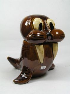 a ceramic figurine that looks like a beaver sitting on its side with his mouth open