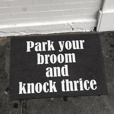 a black door mat that says park your broom and knock thiree on it