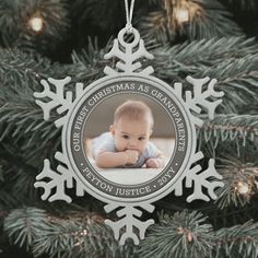 a christmas ornament with a baby's photo hanging from the top of a tree