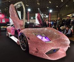 a pink car with its doors open on display