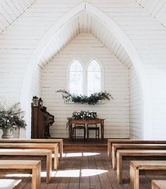 an empty church with white walls and wooden pews