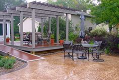 an outdoor patio with table, chairs and umbrellas