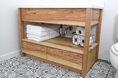 a wooden shelf with towels and toilet paper