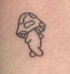 a small mushroom tattoo on the back of a woman's left shoulder and arm