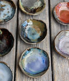 nine different colored bowls sitting on top of a wooden table