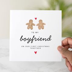 someone holding up a christmas card with two gingerbreads on it that says to my boyfriend