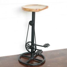 an old fashioned bar stool with a clock on it's back and wheels attached to the seat