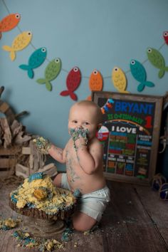 a baby sitting on the floor eating cake