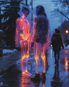 two people are standing in the rain with neon lights on their body and hands behind them