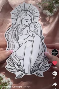 a woman holding a baby in her arms with the image of jesus and mary on it