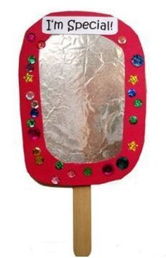 an image of a hand made mirror on a wooden stick with tin foil over it