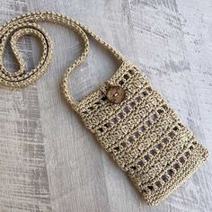 a crocheted purse sitting on top of a wooden floor next to a string