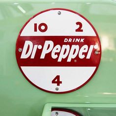 a red and white sign with the words drink dr pepper written on it's side