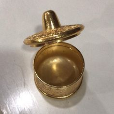 a gold colored metal container sitting on top of a table