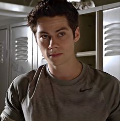 a young man is standing in front of lockers