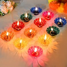 many colorful candles are lit on a table