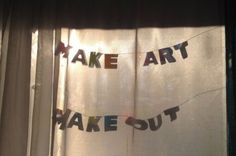 the words make art and bake out are hanging on a curtain in front of a window