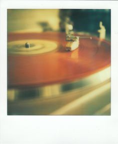 an old - fashioned record player is spinning on the turntable with blurry background