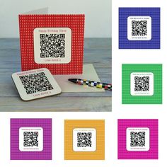 four different colored cards with qr code on them and a pen in the middle