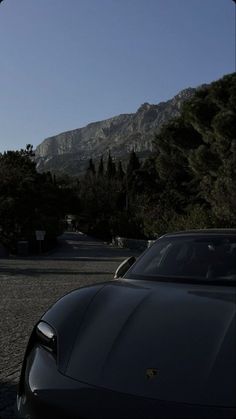 a black sports car parked in front of a mountain