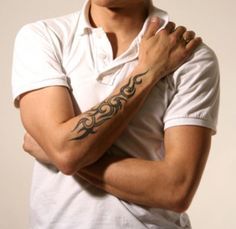 a man with a tattoo on his arm and arms is posing for the camera while wearing a white polo shirt