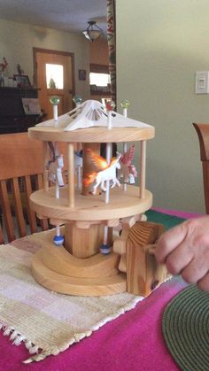 a person is playing with a wooden toy house