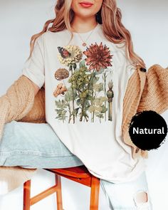 ABOUT OUR Wild Flowers T-Shirt, Vintage Botanical Tee, Pastel Floral Nature T-Shirt, Garden Lover Tee, Flower Lover Tee, Wildflowers Cottagecore Shirt: PRODUCTION TIME: 1-3 business days (Usually 2 business days) SHIPPING TIME: 2-5 business days (Usually 3 business days) PRODUCT DESCRIPTION: Bella Canvas Unisex T-shirt Super soft cotton and excellent quality print makes. 100% Soft cotton (fibre content may vary for different colors) Light fabric (4.2 oz/yd² (142 g/m Runs true to size Our Relaxed White T-shirt With Fall Themed Plant Print, White T-shirt With Plant Print For Fall, Spring Botanical T-shirt With Floral Design, Vintage White Tops With Plant Print, Spring Botanical Flower T-shirt, Botanical Plants Print T-shirt For Spring, Spring Botanical T-shirt With Plant Print, Cottagecore T-shirt With Plant Print For Spring, Spring Cottagecore T-shirt With Plant Print