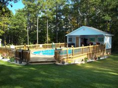 a small pool in the middle of a yard with a deck and gazebo next to it