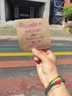 a person holding up a piece of paper with writing on it that reads, pasadas el exam de adonis de la uni extoli