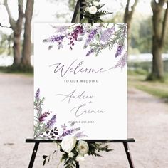 a welcome sign with purple flowers and greenery