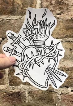 a hand holding up a sticker with flames on it